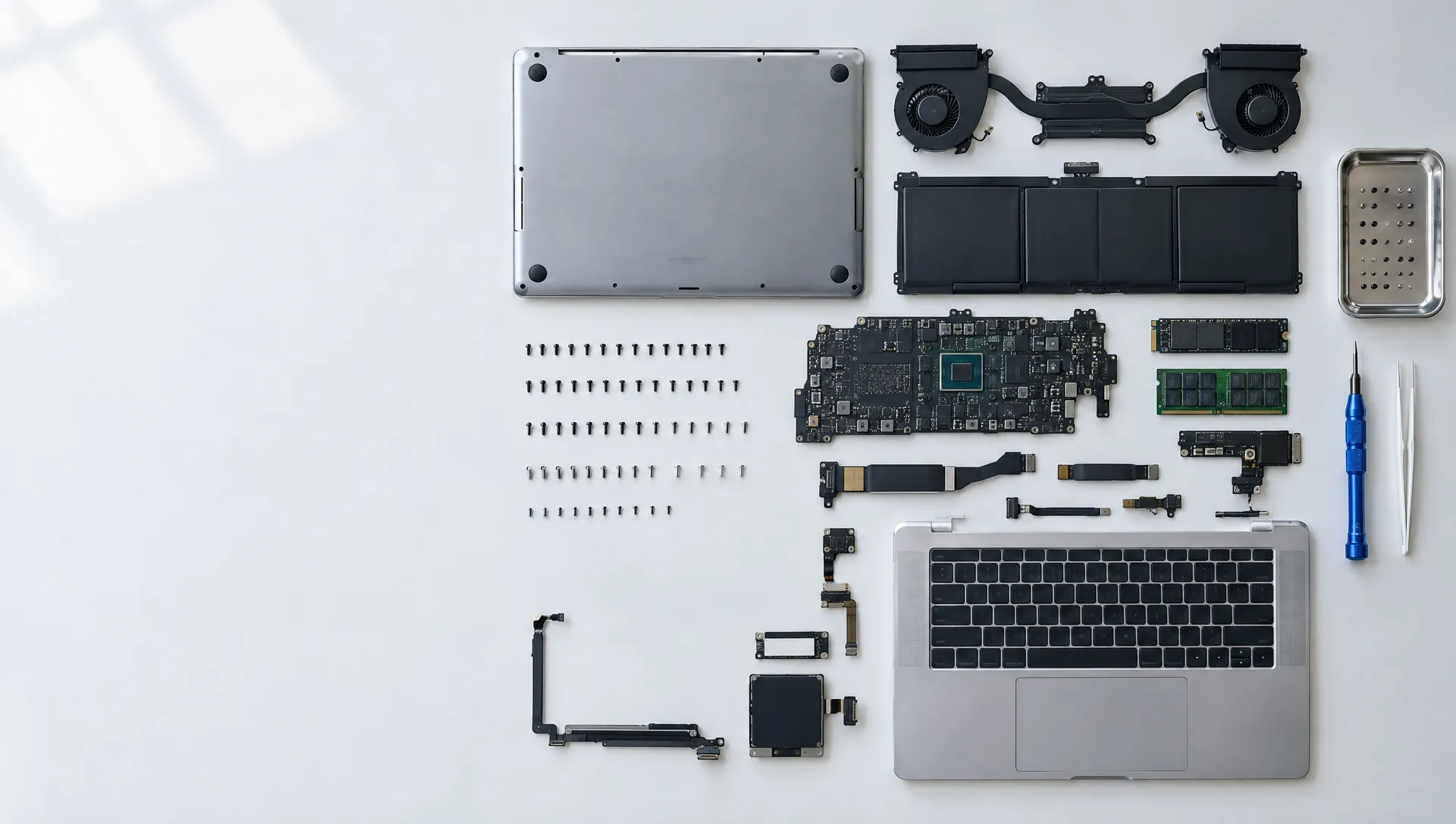 A 14-inch laptop fully disassembled and laid out part by part on a pale workbench
